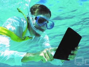 Homme sous l'eau avec masque et tuba consultant une tablette