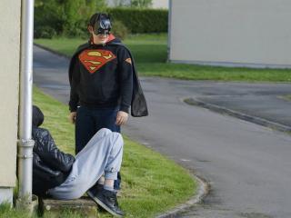 Un adolescent déguisé en superman se tient dehors