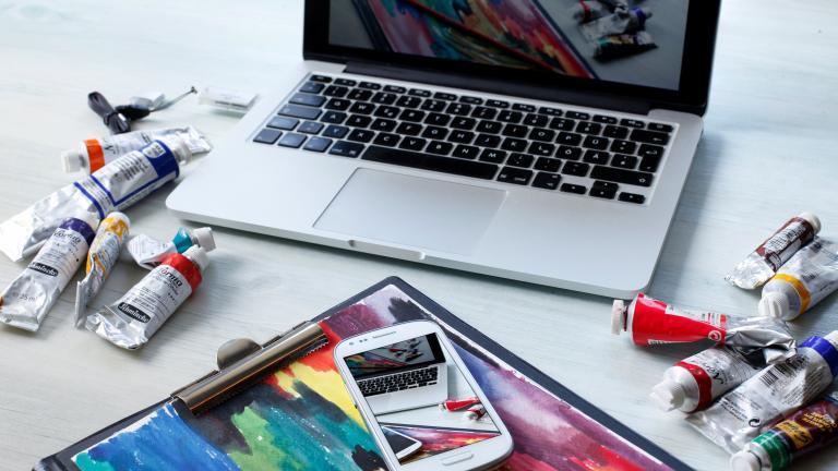 Ordinateur portable avec des tubes de gouache et un smartphone